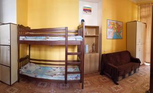 Pokój z 2 łóżkami piętrowymi i krzesłem w obiekcie PANORAMI Apart Hostel in Lviv w Lwowie