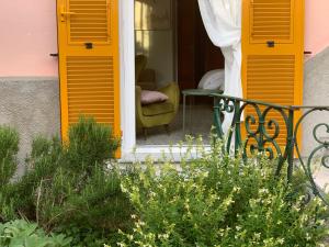 una casa con persiane gialle sul portico anteriore di Casa Righetti a La Spezia