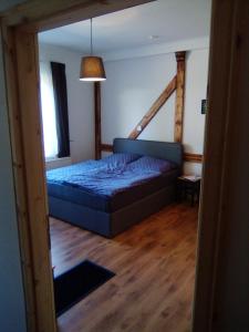 ein Schlafzimmer mit einem blauen Bett in einem Zimmer in der Unterkunft Ferienappartement Studio " Michel" Otzenhausen in Nonnweiler