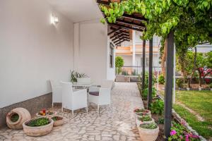 a patio with a table and chairs and plants at Vila Adriatik in Ulcinj