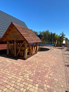 eine hölzerne Spielstruktur mit einem Spielplatz im Hintergrund in der Unterkunft Komfortowe Domki Dar in Sianożęty