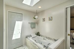 een badkamer met een bad en een raam bij Spacious Family Home on Golf Course Hike and Bike! in Bremerton