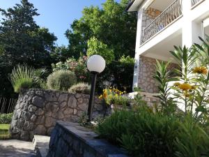 a garden in front of a house at Apartments 4U in Omišalj