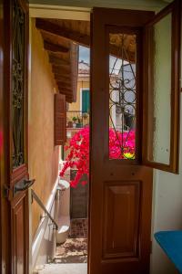 an open door of a house with pink flowers at Lefkada Town Traditional House / Cozy Yard in Lefkada Town