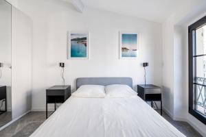 - une chambre blanche avec deux tables et un lit dans l'établissement SMARTBNB - Moderne 2 pieces Port de Nice, à Nice