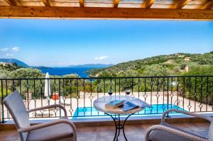 een tafel en stoelen op een balkon met uitzicht bij Villa Kallisti in Meganisi