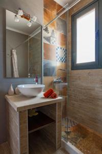 a bathroom with a sink and a glass shower at Villa Kallisti in Meganisi +12 photos