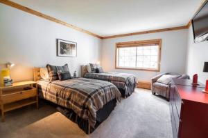 a bedroom with two beds and a desk and a television at Nine Vail Road in Vail Village in Vail