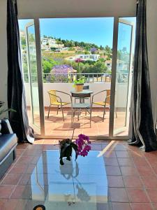 a living room with a table and a view of a balcony at Costadelsolflat in Benalmádena