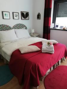 a bedroom with a large bed with a red blanket at Moradia no Seixal Ericeira in Ericeira