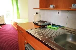 a kitchen with a sink and a counter top at Pokoje Gościnne Orka in Jarosławiec +17 photos