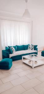 uma sala de estar com um sofá azul e uma mesa em Aneta's Beach House em Vlorë