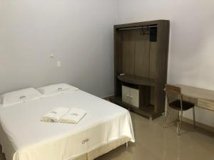 una camera da letto con un letto e due asciugamani di Hotel Colinas a Várzea Grande