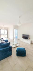 uma sala de estar com um sofá azul e uma televisão em Aneta's Beach House em Vlorë
