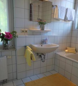 a white bathroom with a sink and a mirror at Kurparkhotel Faißt in Bad Peterstal-Griesbach