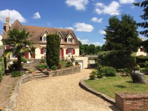 a house with a gravel driveway in front of it at La Noisetiere in Noyers-sur-Cher