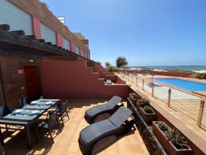 a patio with tables and chairs next to a swimming pool at Marfolín 10 in El Cotillo