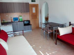 una pequeña cocina con mesa y sofá rojo en MARGARITA'S-STUDIOS en Koufonisia