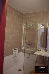 a shower with a glass door in a bathroom at Hôtel Restaurant Le chanel in Villieu