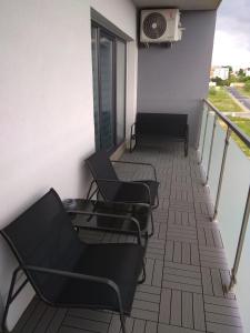 - un balcon avec des chaises et un radiateur dans un bâtiment dans l'établissement Apartament Miedzianka II, à Polkowice