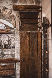 porta in legno in una stanza con parete in pietra di Appartamenti montemezzo le case in pietra Vista lago a Gera Lario