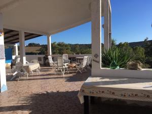 a patio with chairs and a table and a table and chairs at Garden Rooms in Carloforte
