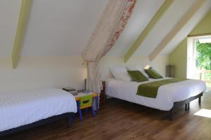 a bedroom with two beds and a window at Le Domaine du Pont Canon in Plourivo