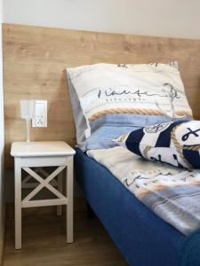 sypialnia z niebieskim łóżkiem i stolikiem nocnym ze stolikiem w obiekcie Apartamenty u Rybaka w Jastarni