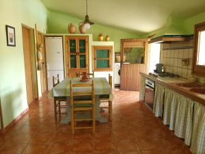 a kitchen with a table and chairs in a room at La Caseta de Mollet in Benifallet