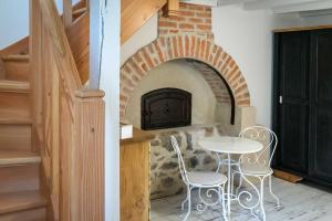 a room with a table and a brick fireplace at au Mas de Garet - hébergements de charme in Pinsac