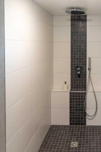 ein Bad mit einer Dusche mit schwarzen und weißen Fliesen in der Unterkunft au Mas de Garet - Chambre d'hotes de Charme in Pinsac