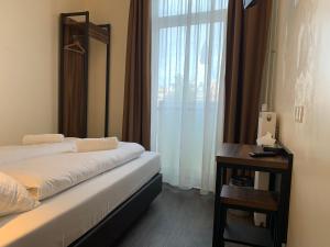 une chambre d'hôtel avec un lit, une table et une fenêtre dans l'établissement Orange Tulip Hotel, à Amsterdam
