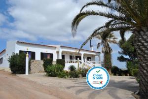 a white house with a sign in front of it at Vivenda Familia Pedro in Vila do Bispo