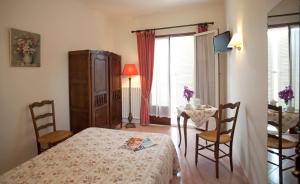 una camera con letto, tavolo e sedie di Hotel Belle Vue a Le Lavandou