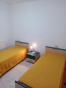 een kamer met twee bedden en een lamp op een tafel bij CASA BEPPA in Pomonte