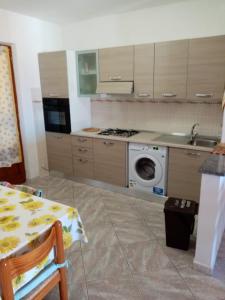 een keuken met een fornuis en een wasmachine bij CASA BEPPA in Pomonte