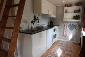 SkärblackaÅngsågen的厨房配有白色橱柜和水槽