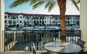 a balcony with a table and chairs and a palm tree at Naples Bay Resort and Marina in Naples