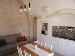 a living room with a table and a couch at Trulli stett in Cisternino