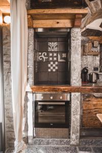 a kitchen with a stove top oven in a room at Appartamenti montemezzo le case in pietra Vista lago in Gera Lario