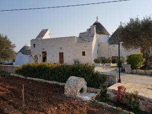 a large white building with a roof at Trulli stett in Cisternino
