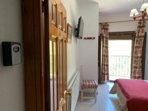 a room with a bed and a door with a window at Hostal Atalaya in Capileira