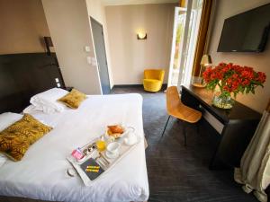 a hotel room with a tray of food on a bed at Hotel Molière in Cannes