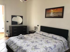 Schlafzimmer mit einem Bett, einer Kommode und einem Spiegel in der Unterkunft Miluna B&B in Nocera Umbra