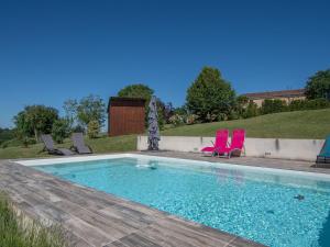a swimming pool with two pink chairs at Spacious Holiday Home in Sauveterre de l mance in Sauveterre-la-Lémance