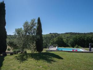 a view of a swimming pool in a park with trees at Spacious Holiday Home in Sauveterre de l mance in Sauveterre-la-Lémance