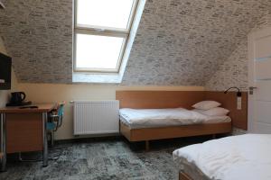 a bedroom with two beds and a desk and a window at Motelik Grosar Jasło in Jasło