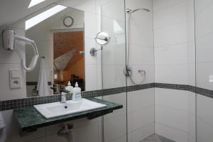 a bathroom with a sink and a shower at Motelik Grosar Jasło in Jasło