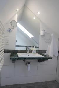 a white bathroom with a sink and a mirror at Motelik Grosar Jasło in Jasło