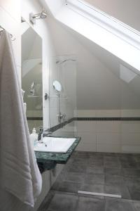 a bathroom with a sink and a shower at Motelik Grosar Jasło in Jasło